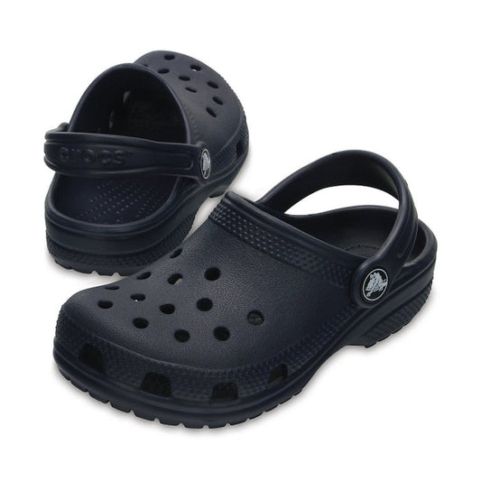 The Crocs Kids - Classic Clog K Navy Youths is a pair of navy blue clogs made from lightweight Croslite, featuring ventilation holes and adjustable heel straps, shown on a white background.
