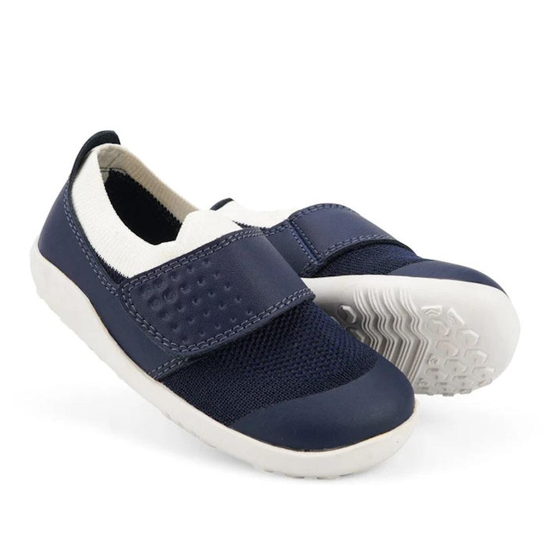 The Bobux Iwalk Lo Dimension III Blue Navy Trainer 638506 Unisex is a pair of navy slip-on children's shoes with white soles, a textured top strap, twin-face merino knit upper, flexible sole, and heel pull tab.