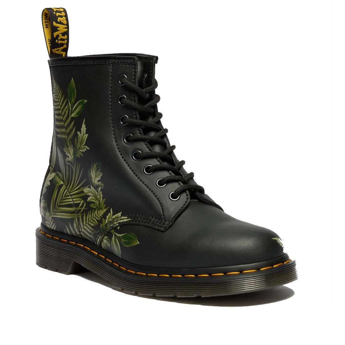 The 1460 Dr Martens Smooth EverGreen Leather 8 Up Boot features a black background with tropical green leaf patterns, yellow-stitched sole, and a black and yellow heel pull tab.