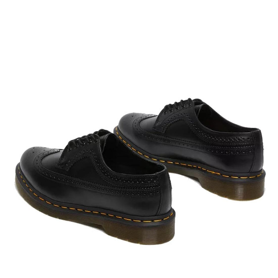 A view from the heel of a Dr Martens 5 eye 3989 brouge black leather shoe showing detaling and yellow stitching around the sole.,
883985987371,
883985987388,
883985987395,
883985987425,, 44361, 44362, 44363, 44364, 883985987371, 883985987388, 883985987395