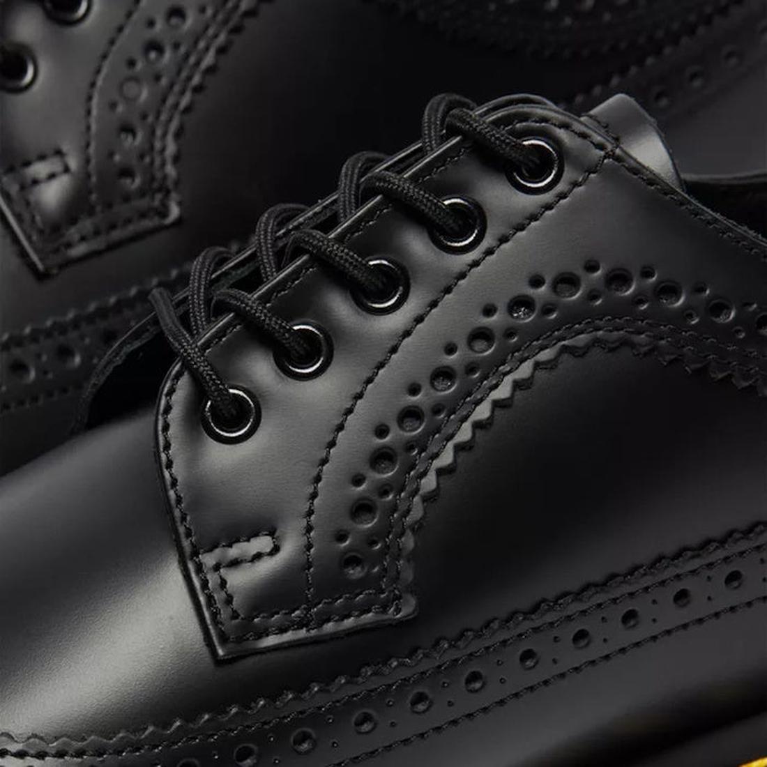 a shot showing the brogue cut out hole detaliing by the eyelets of a Dr Martens 3989 5 eye black leather shoe.,
883985987371,
883985987388,
883985987395,
883985987425,, 44361, 44362, 44363, 44364, 883985987371, 883985987388, 883985987395, 44368, 883985987