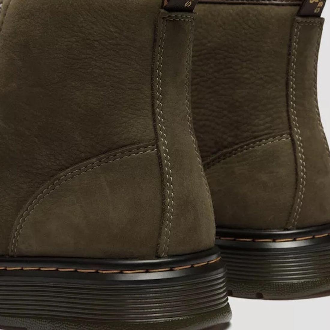 Close-up of the back of two Dr. Martens Brookline Chukka Boots in olive milled nubuck leather, showing visible stitching, black midsoles, heel pull tabs, and a lightweight outsole for comfort., 51342, 190665797053, 190665797060, 190665797084, 190665797091