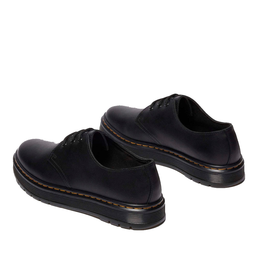 A pair of Dr Martens Brookline Dark Black Lusso Leather Shoes with thick black soles and subtle brown stitching, crafted from lightweight leather, displayed on a white background.