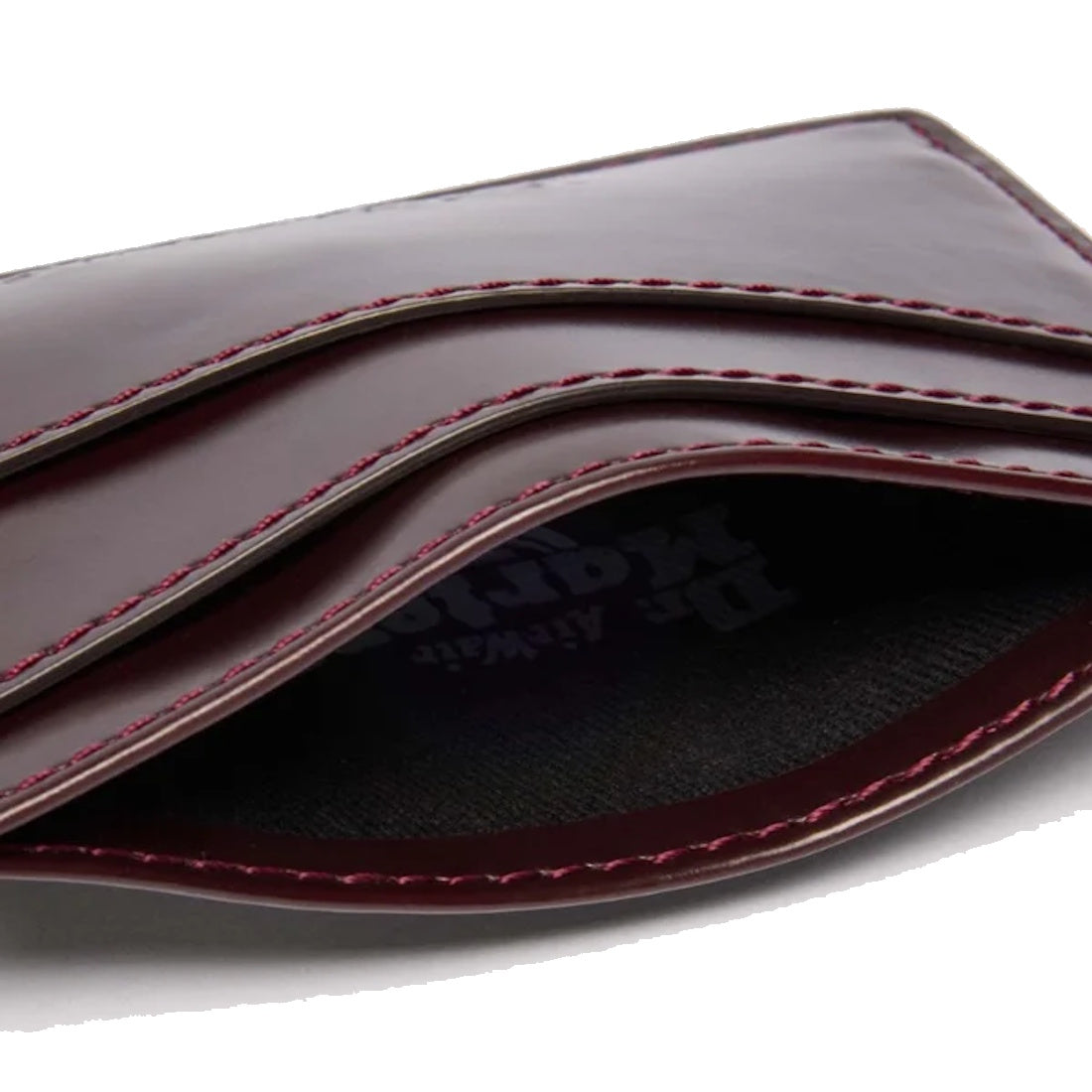 A close-up of the Dr Martens Card Holder II Cherry Red Oxford Brush Vegan, featuring visible stitching and multiple card slots, highlights the refined appeal of this minimalist vegan accessory.