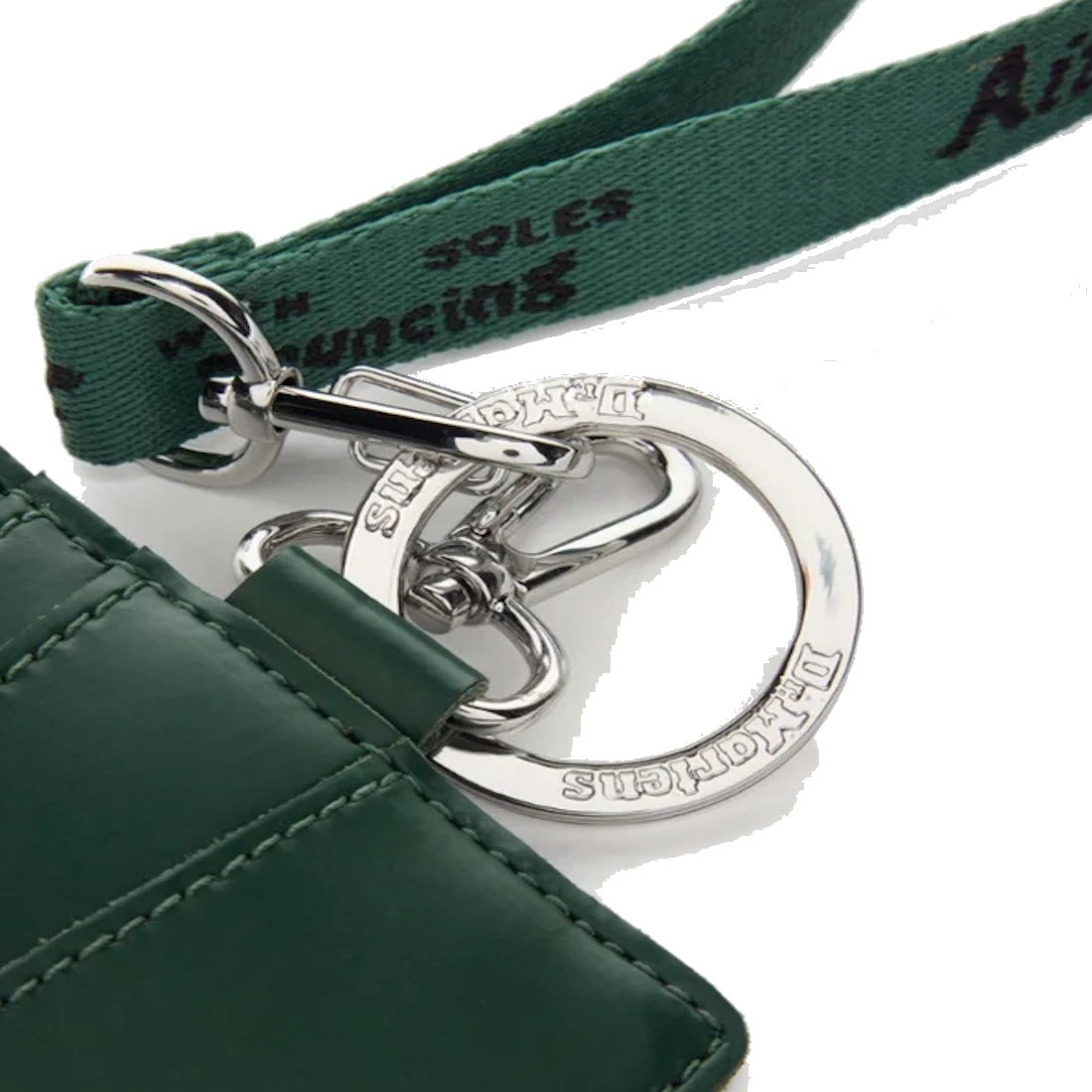 Close-up of the Dr Martens Card Holder Keyring Green Kiev Leather Bag Charm, featuring a quilted pattern, green fabric strap, silver DR. MARTENS-engraved keyring, and a zippered coin compartment for added convenience.