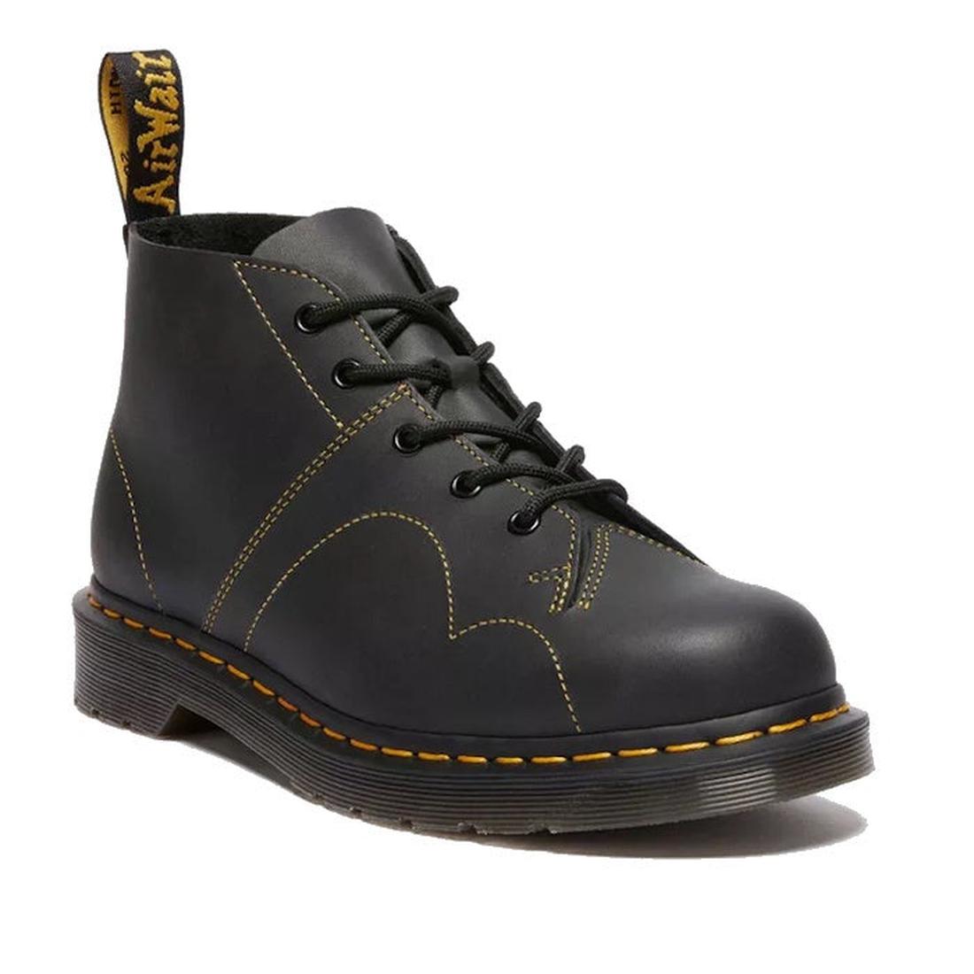The Dr Martens Church Monkey Boot Black Greasy features black leather, yellow stitching, a thick air-cushioned sole, and a branded back pull tab—resembling the classic Dr. Martens style.