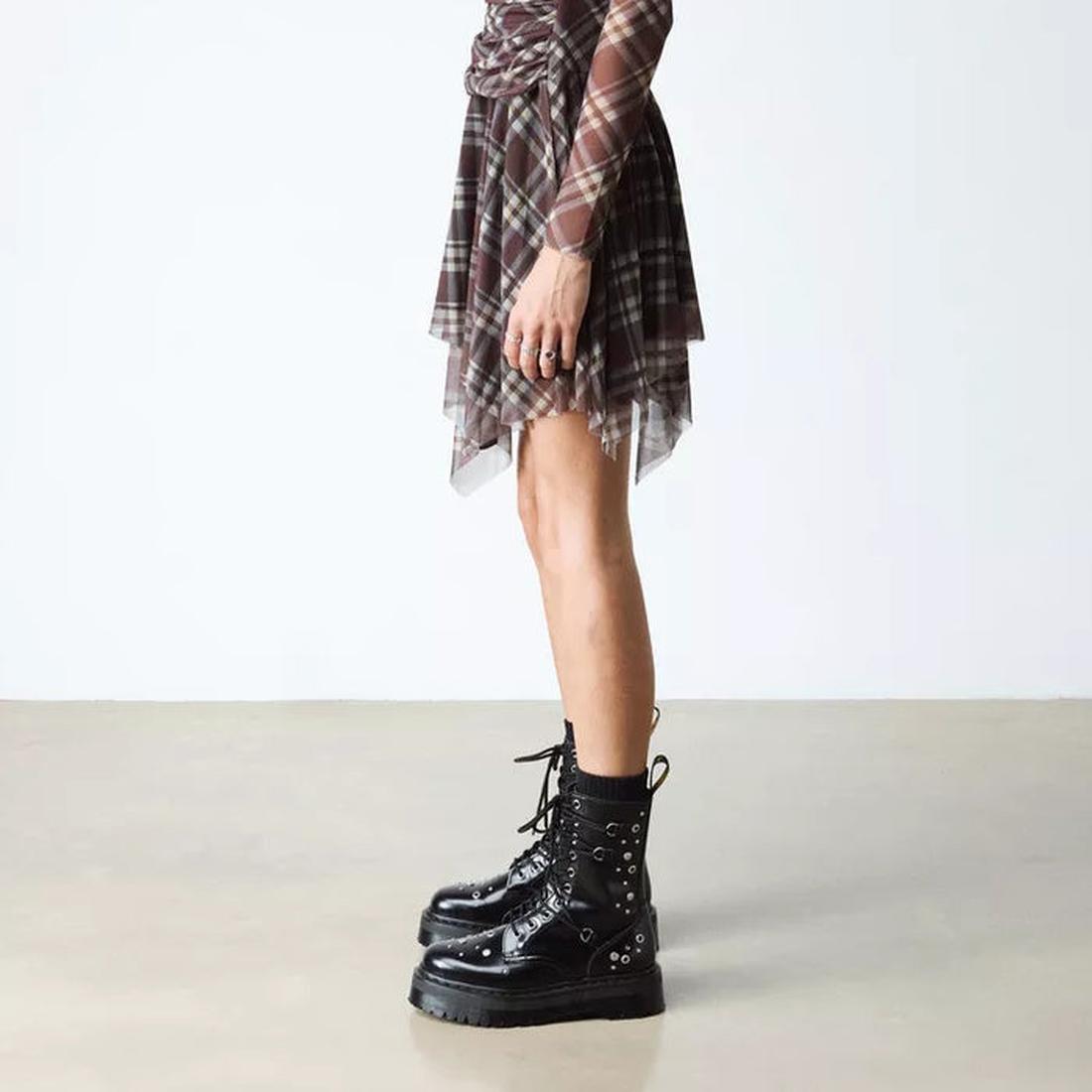A person stands indoors on a plain background wearing a brown plaid skirt, matching long-sleeve top, black socks, and Dr Martens Jadon Hi HDW Hardware Buttero Platform Black Boots., 190665797862, 190665797879, 190665797893