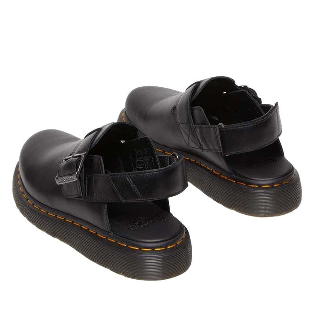 The Dr Martens Black Jorge II Brando Sling Back Sandal features a covered toe mule design in full grain leather with thick soles, open backs, adjustable straps, and signature yellow stitching. The sandals are shown slightly apart on a white background., 2