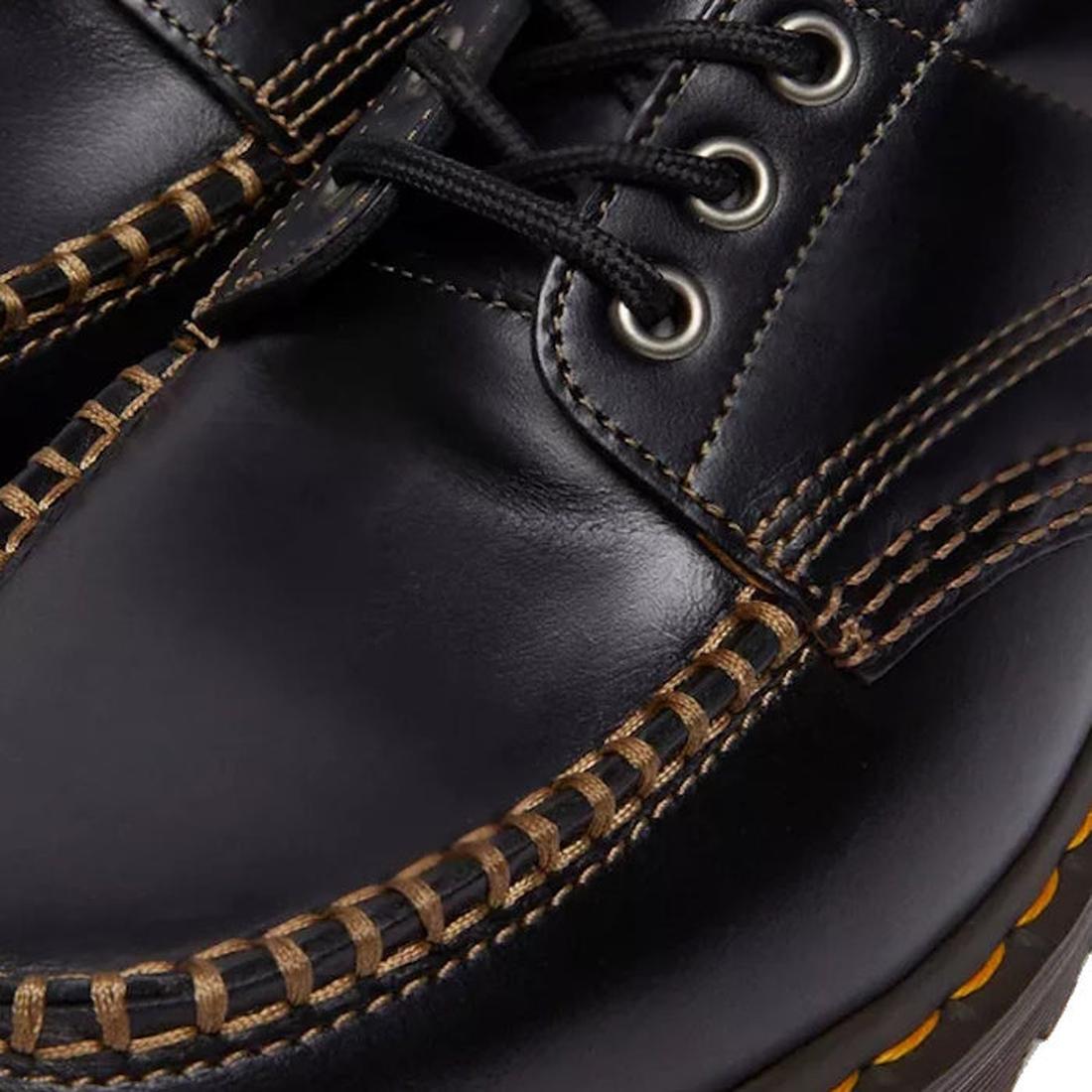 Close-up of the Dr Martens Lowell Moc Toe Black Leather Shoe, featuring black Analine leather, thick brown stitching, metal eyelets for laces, and Goodyear welted construction that showcases exceptional craftsmanship., 50395, 50396, 50397, 50398, 50399, 1