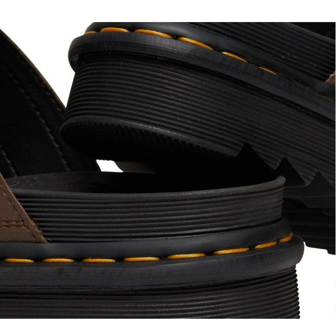 Close-up of two stacked Dr Martens Myles Dark Brown Oiled Illusion Sandals, featuring thick soles with yellow stitching, textured rubber detail, brown uppers, and adjustable buckle straps., 26562, 190665523188, 190665523195, 190665523201, 190665523218, 19