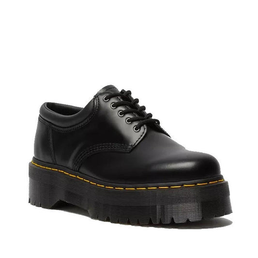 The Dr Martens 8053 Quad 5 Eye Shoe features black Polished Smooth leather, thick chunky quad soles, and signature yellow stitching, shown lace-up on a white background.