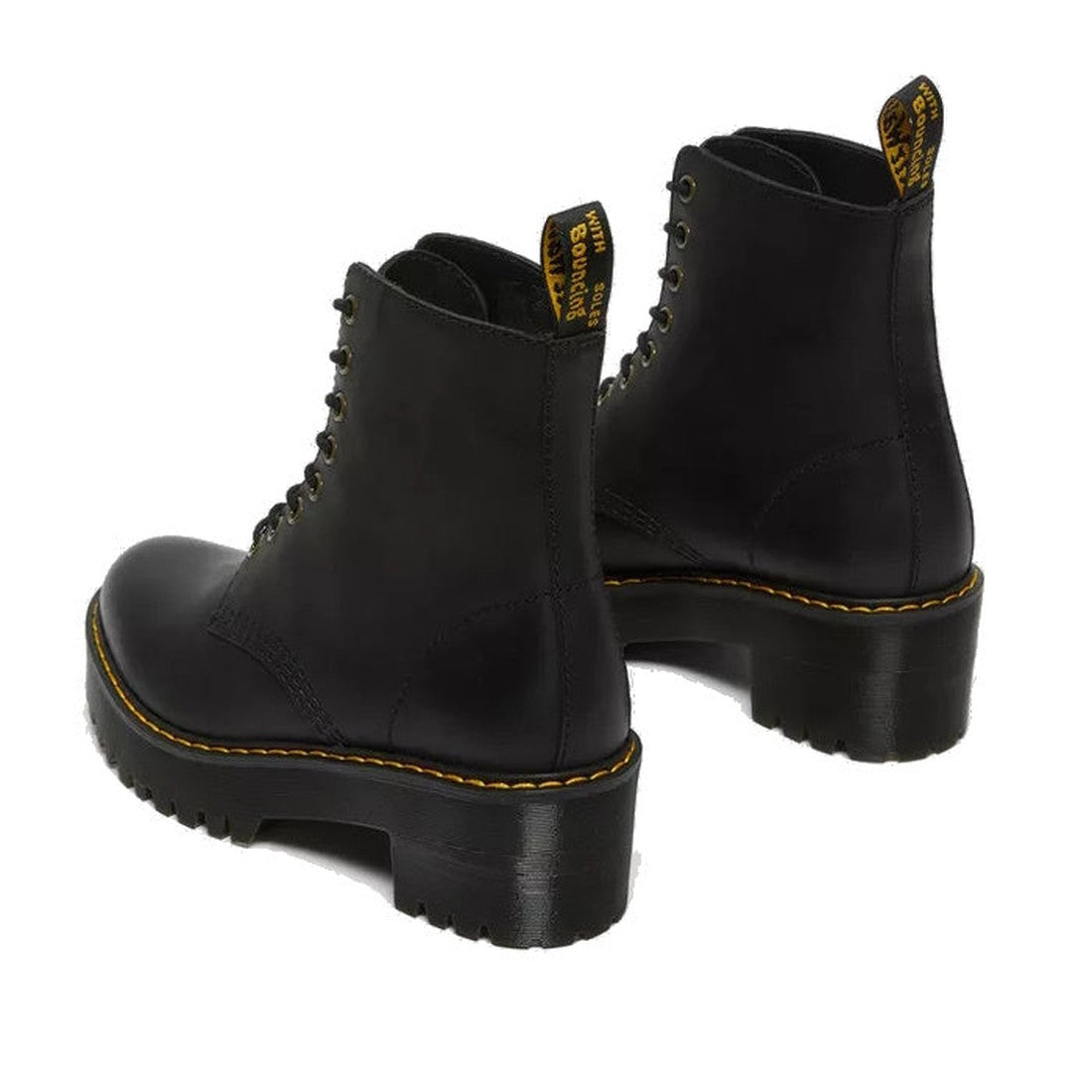 A pair of Dr Martens Women's Shriver Hi Lace Up Leather Boots in black, featuring thick soles, yellow stitching, black pull tabs, and crafted from Burnished Wyoming leather, shown from a rear angled view., 190665158588, 190665158595, 190665158601, 1906651