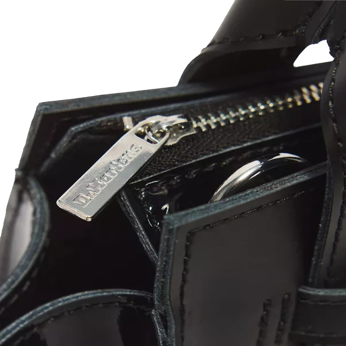 Close-up of the Dr Martens Small Keiv Leather Tote Bag in black, featuring a shiny patent leather surface and detailed stitching. The silver zipper pull, engraved with Dr. Martens, is visible, while sleek patent Lamper straps enhance the bag’s modern aest