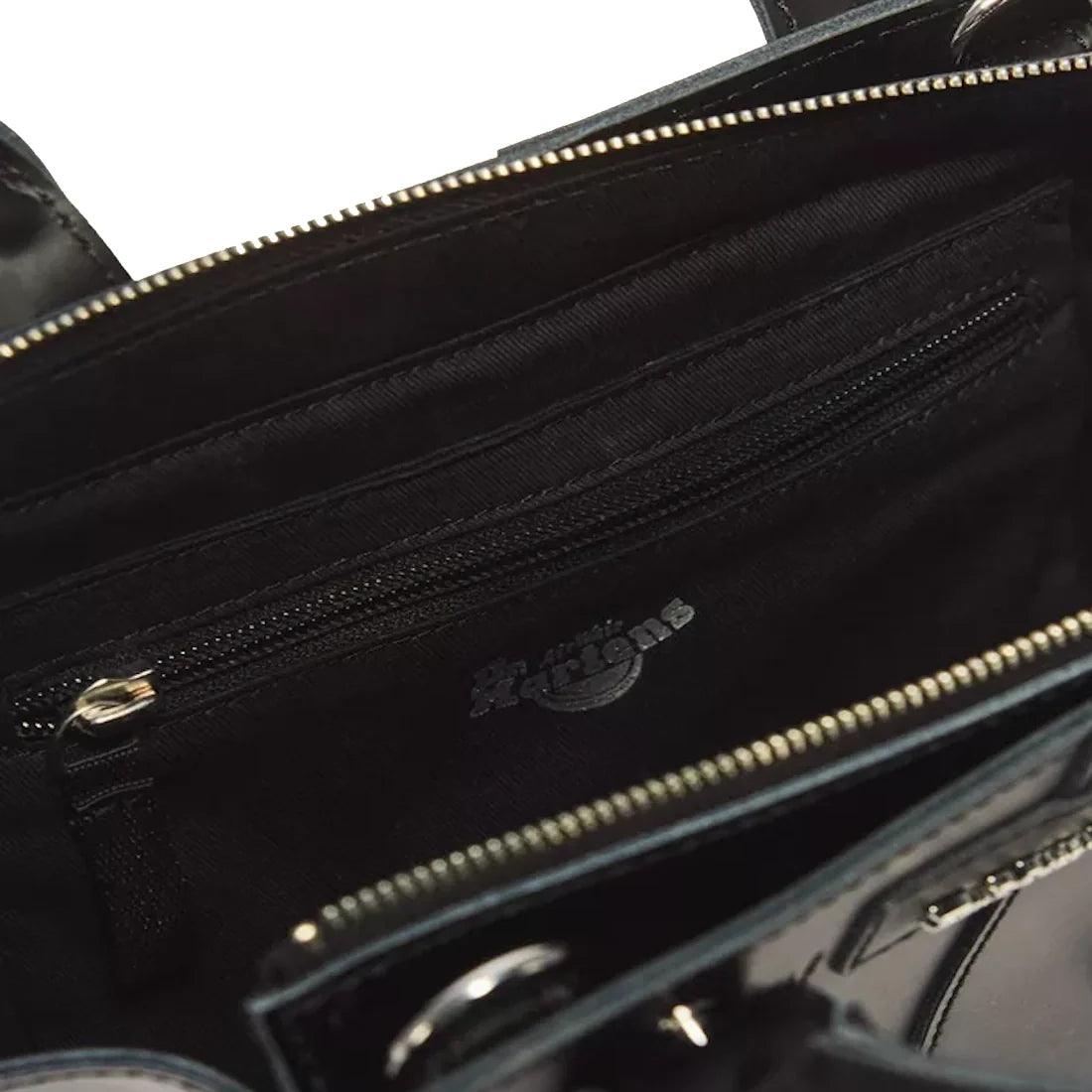 Close-up of the Dr Martens Small Keiv Leather Tote Bag in black, crafted from premium Keiv leather. The bag features a zippered inner pocket and is finished with sleek patent Lamper straps. The zipper and fabric details are clearly visible inside the bag.