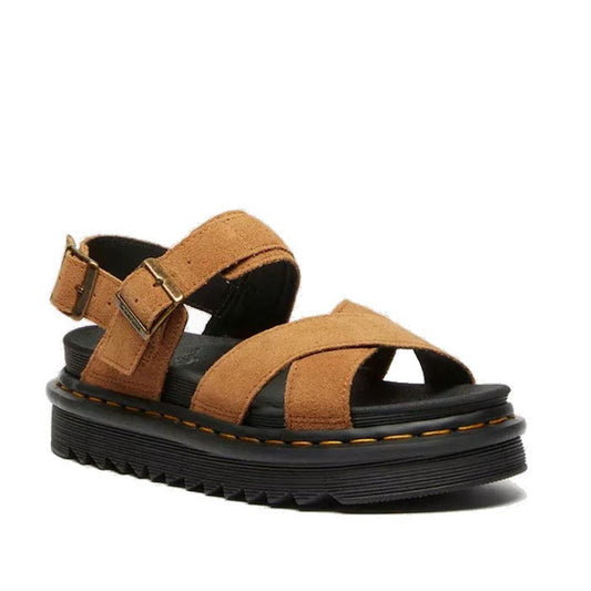 The Dr Martens Voss II Cross Strap Sandal in Tan VT EH Suede features brown suede crisscross straps, buckle closures, a thick black platform sole with yellow stitching, and a memory foam footbed for all-day comfort.
