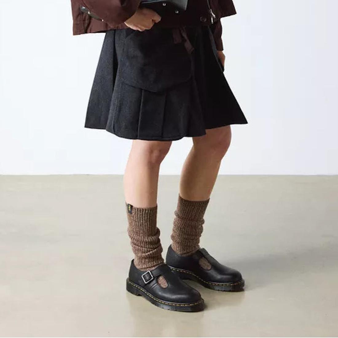 Person wearing a black skirt, brown knee-high socks, and black Dr Martens Polley T Bar  shoes on a plain background.,
190665740530,
190665740547,
190665740561,, 46179, 46180, 190665740530, 190665740547, 190665740561, 46185, 46186