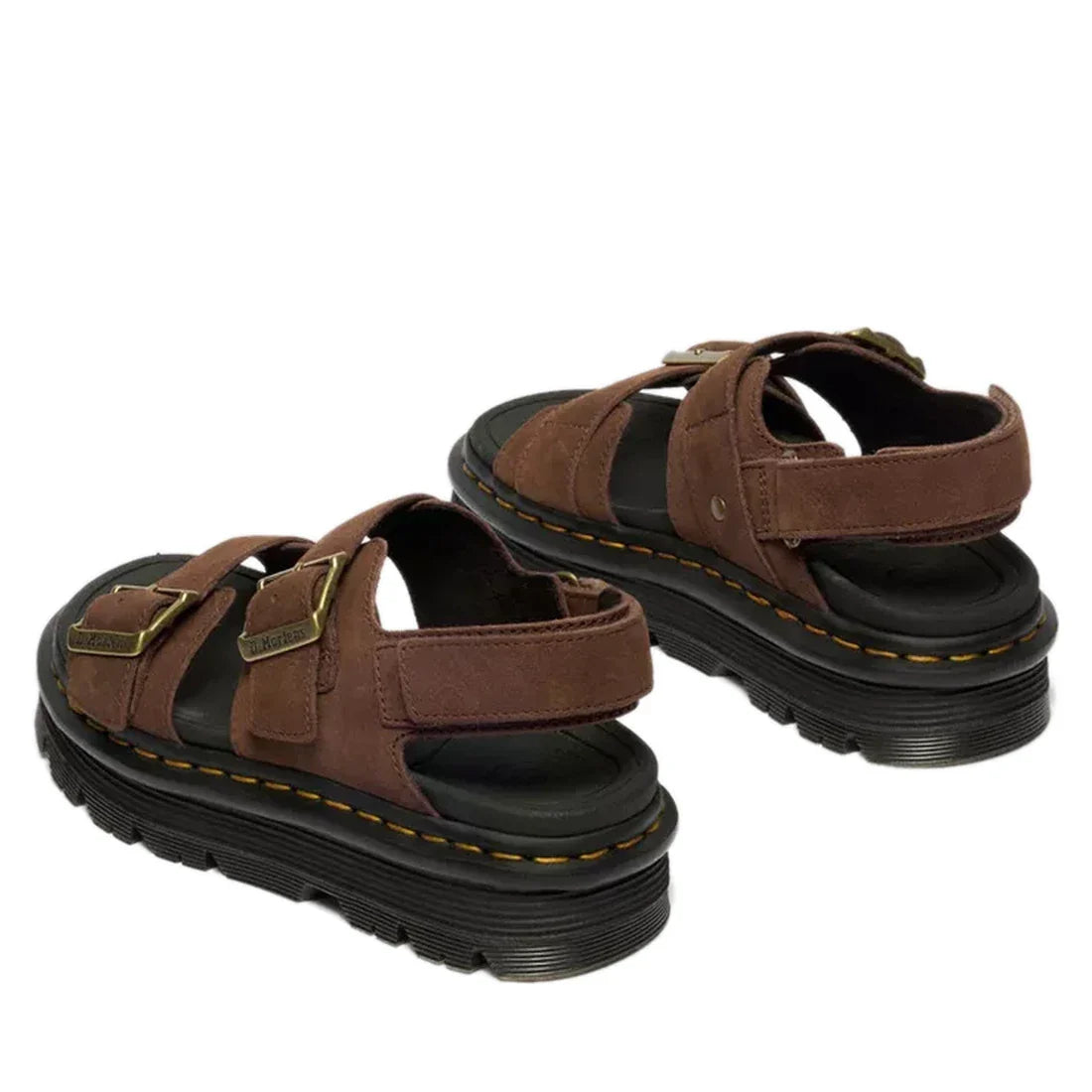 The Dr Martens Zebzag Sepia Brown Nubuck 2 Strap Sandal features milled nubuck leather, thick black soles, yellow stitching, adjustable buckle straps, and open toes and heels, shown from the back at an angle., 190665790603, 190665790610, 190665790627, 190