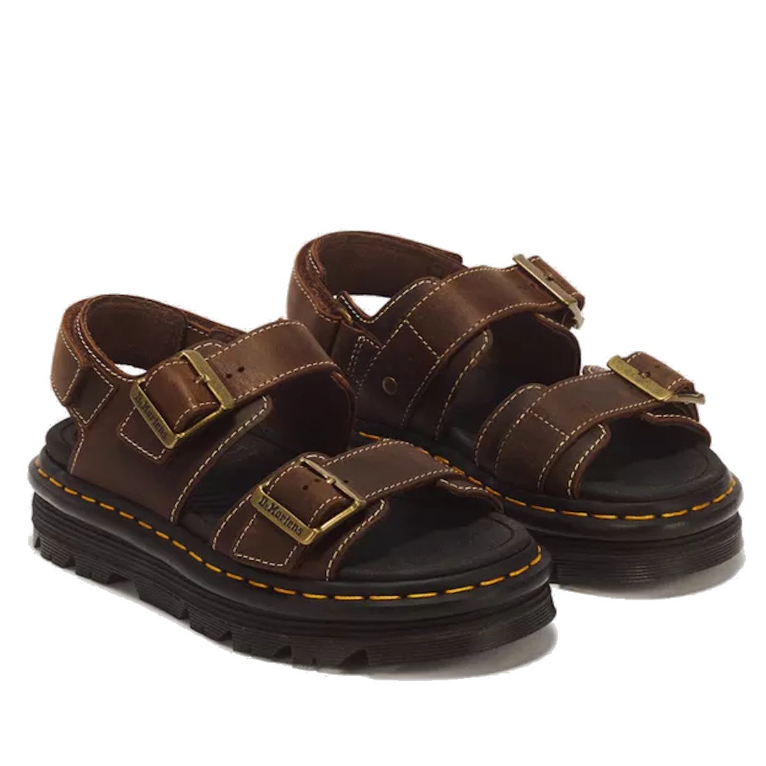 The Dr Martens Zebzag Crazy Horse Brown 2 Strap Sandal features rich brown leather, thick black air-cushioned platform soles, yellow stitching, and two large brass buckles on each sandal.