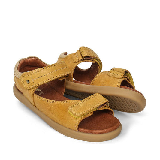 The Bobux Kid+ Plus Driftwood Chartreuse Open Toe Sandal 833507 is a yellow-brown leather kids sandal with adjustable Velcro straps and brown cushioned soles, shown on a white background.