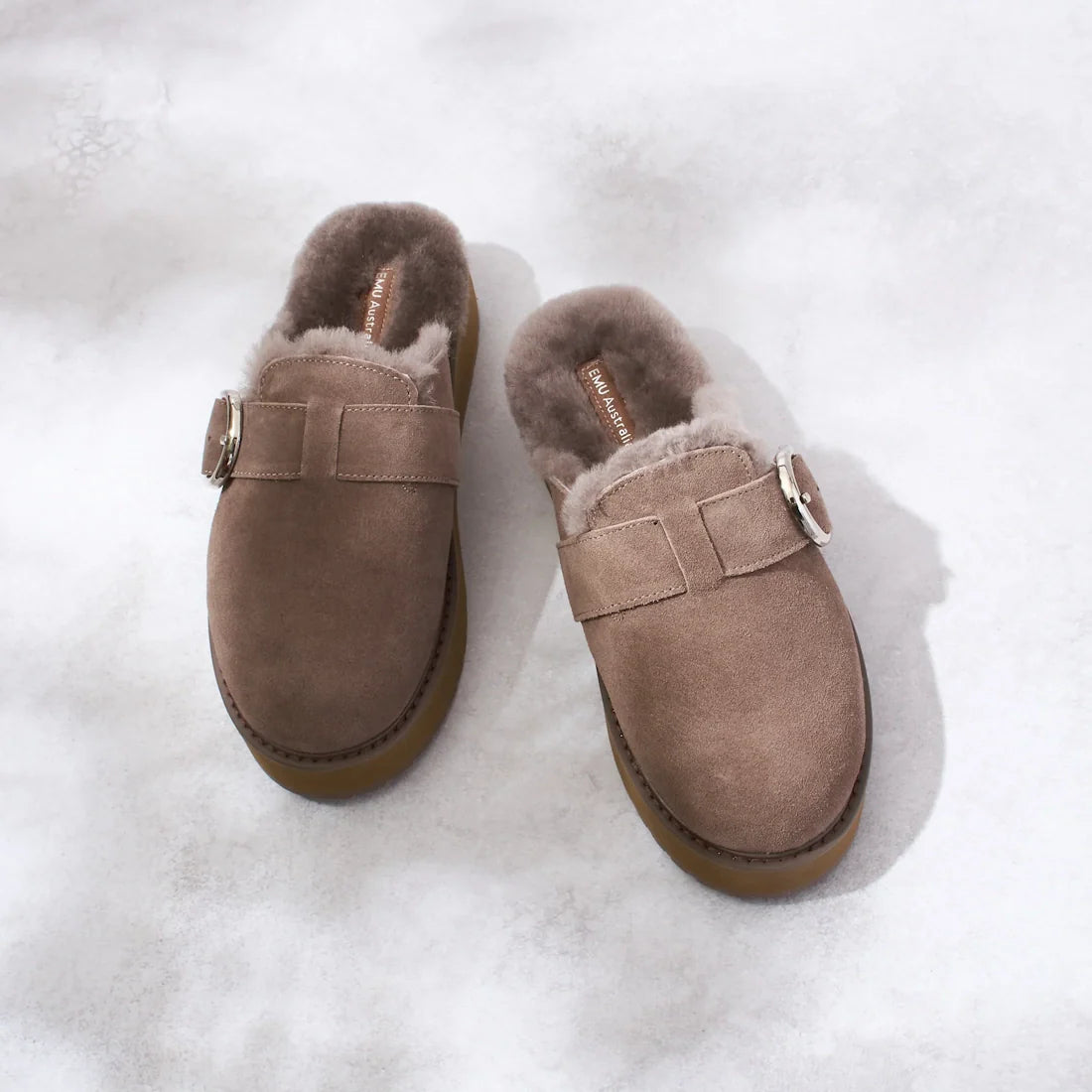 The Emu Womens Adison Smoke Grey Wool Mule Slipper Scuff, featuring a closed-toe slip-on design with a silver buckle and plush grey lining, is displayed on a light, textured surface., 50716, 9330071986417, 9330071986424, 9330071986431, 50720, 50721