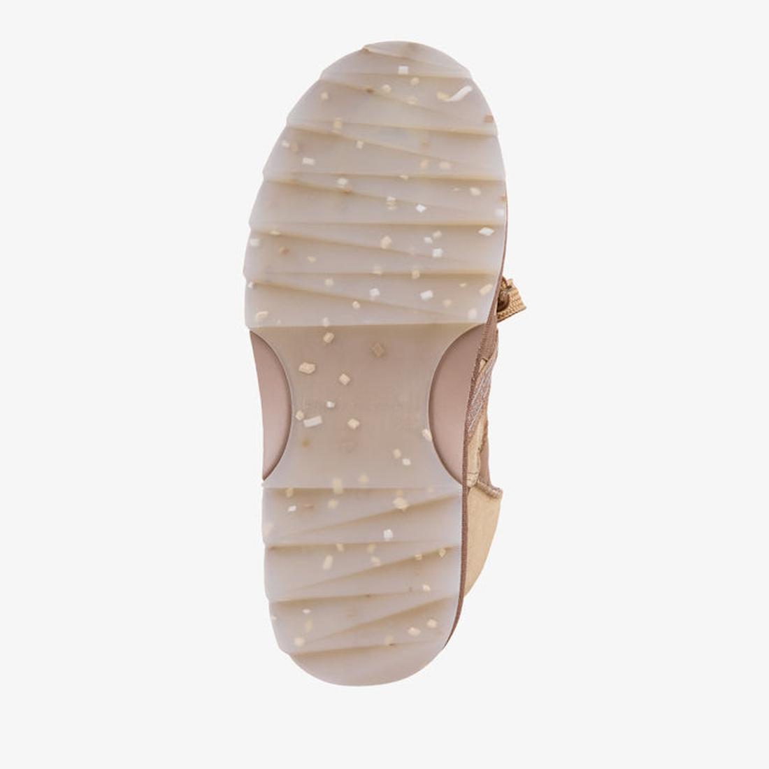 The image shows the bottom view of the EMU Women's Blurred Micro Patchwork Sheepskin Boot in Mushroom, featuring a beige, ridged sole with white and tan specks. Some straps are visible, highlighting the subtle patchwork design of the boot., 47429, 9330071