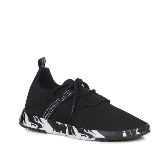 The Emu Womens Leura Swirl Wool Knit Trainer Black features a black wool upper, white and black swirl print sole, black laces, and a heel pull tab, shown against a white background.
