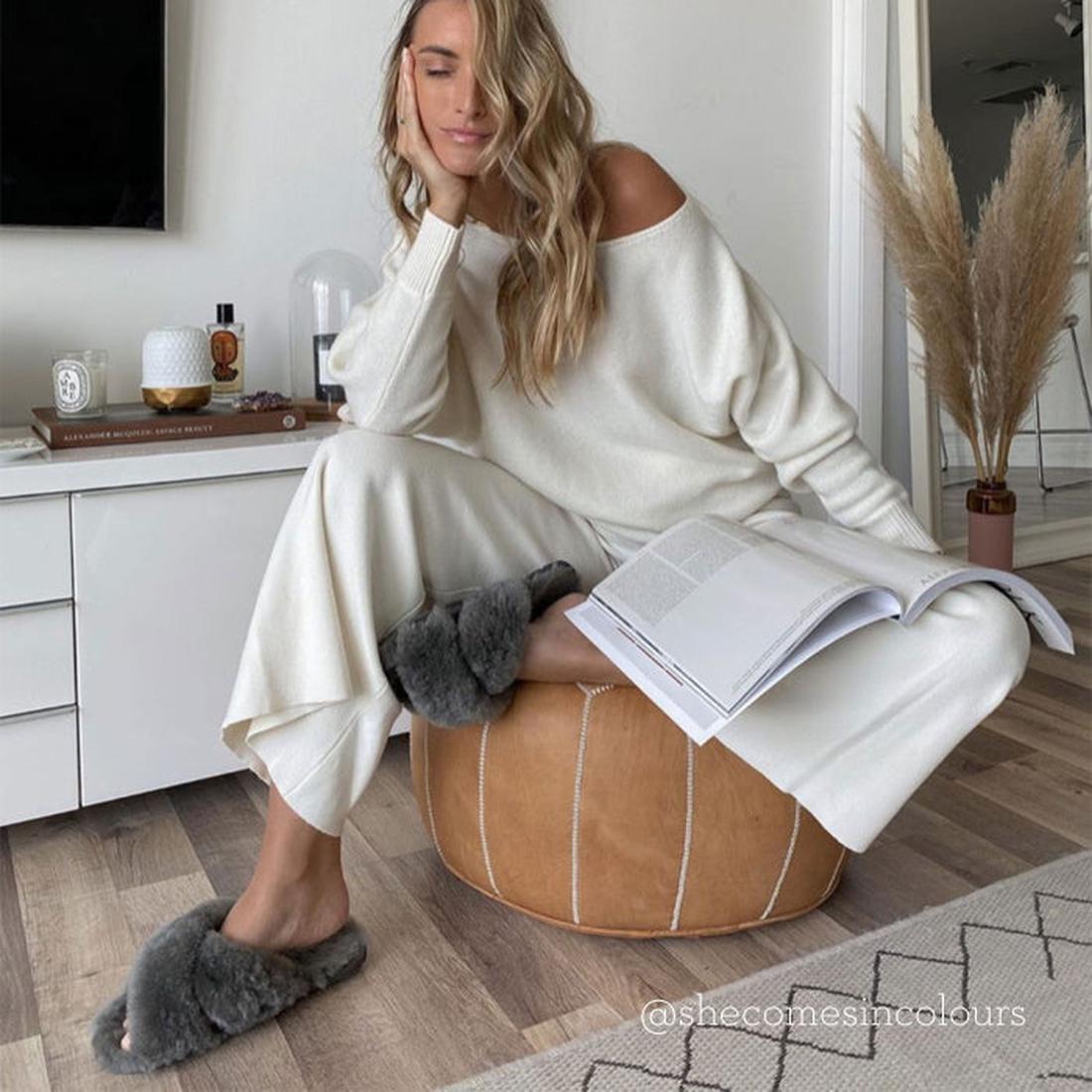 A mom relaxes with a book in EMU NZ Mayberry Scuff Slippers—charcoal grey, open back, plush lining, and sturdy sole for home comfort.  ksnz