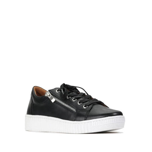 The EOS Joyce Leather Trainer is shown in black Italian Aniline leather with black laces, a side zipper, and a thick white sole against a plain white background. The shoe is angled to highlight both the side and front views.