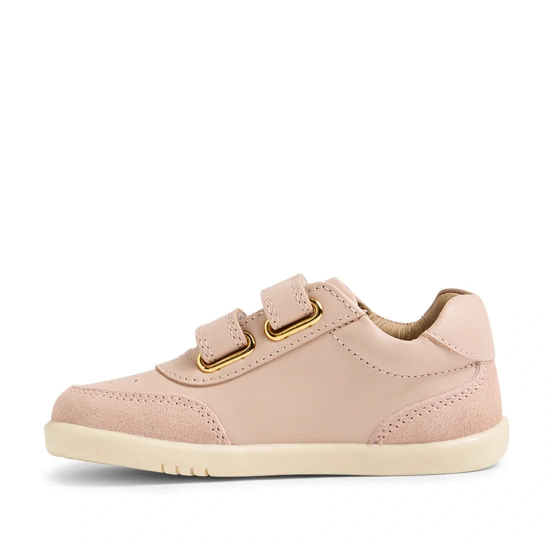Introducing the Bobux IW Iwalk Toddlers Champ Leather Sneaker in Cameo Rose Pink—a light pink leather kids’ sneaker featuring two convenient hook and loop straps, gold eyelets, and a cream-colored sole. Suede accents on the heel and toe add stylish flair,