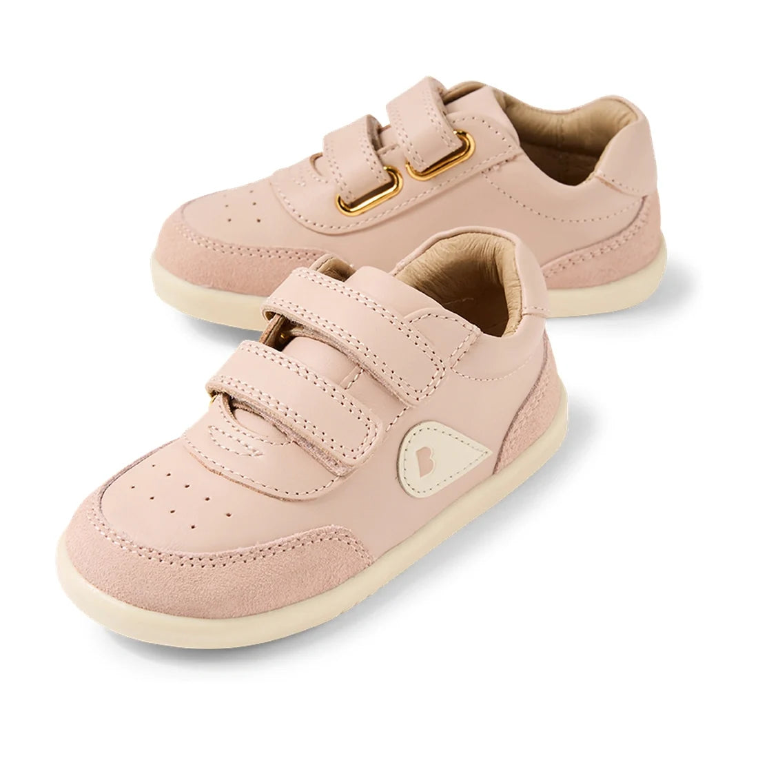 The Bobux IW Iwalk Toddlers Champ Leather Sneaker in Cameo Rose Pink features a light pink design with white soles, convenient hook and loop straps for easy fastening, and a small heart logo on the side, shown against a white background.