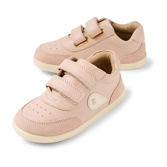 The Bobux IW Iwalk Toddlers Champ Leather Sneaker in Cameo Rose Pink features a light pink design with white soles, convenient hook and loop straps for easy fastening, and a small heart logo on the side, shown against a white background.