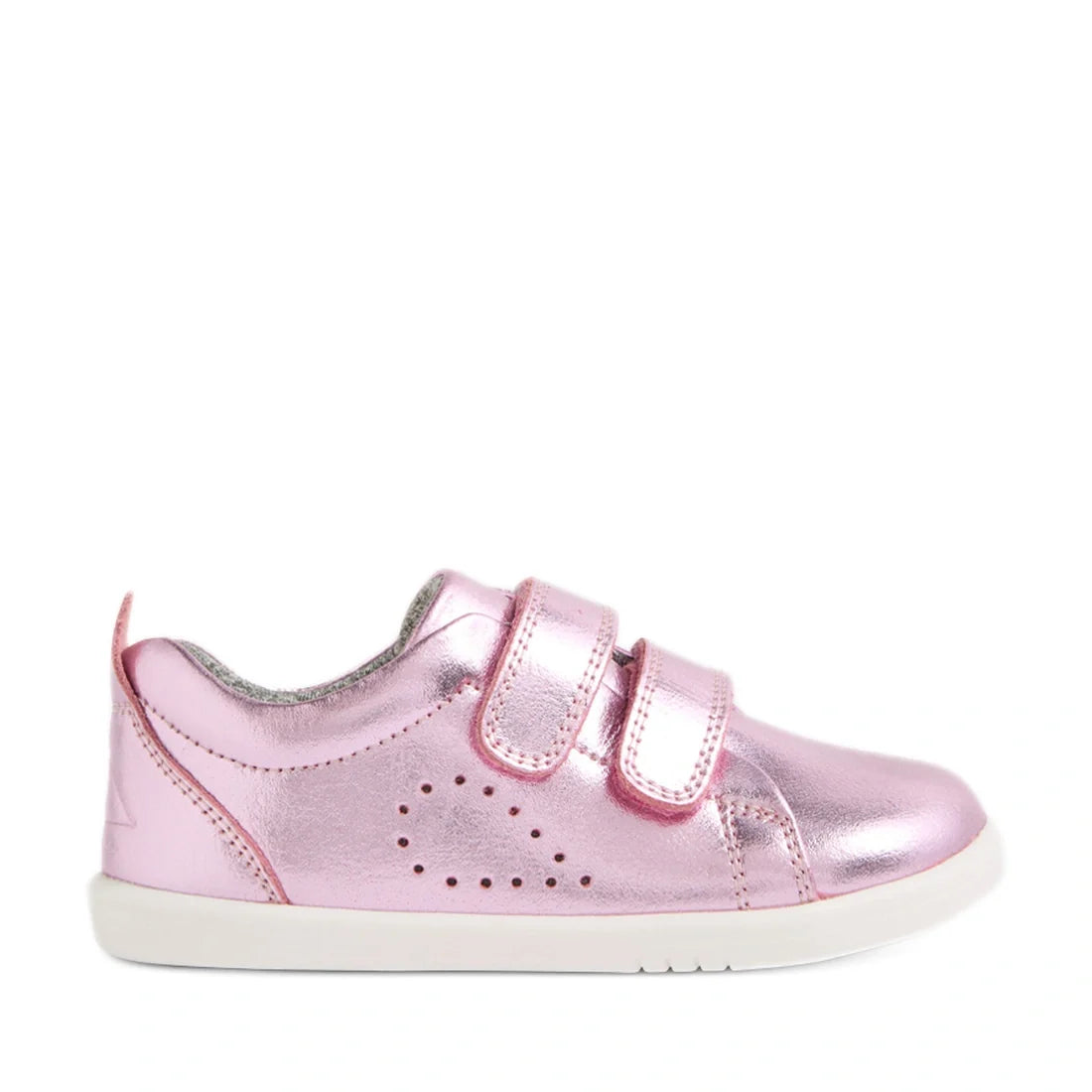The Bobux Iwalk Toddlers Grass Court Pink Metallic Leather Trainer features shiny pink leather, two Velcro straps, small perforated side holes, a cushioned collar, and a white rubber sole—shown in profile on a white background. Perfect toddler trainers in