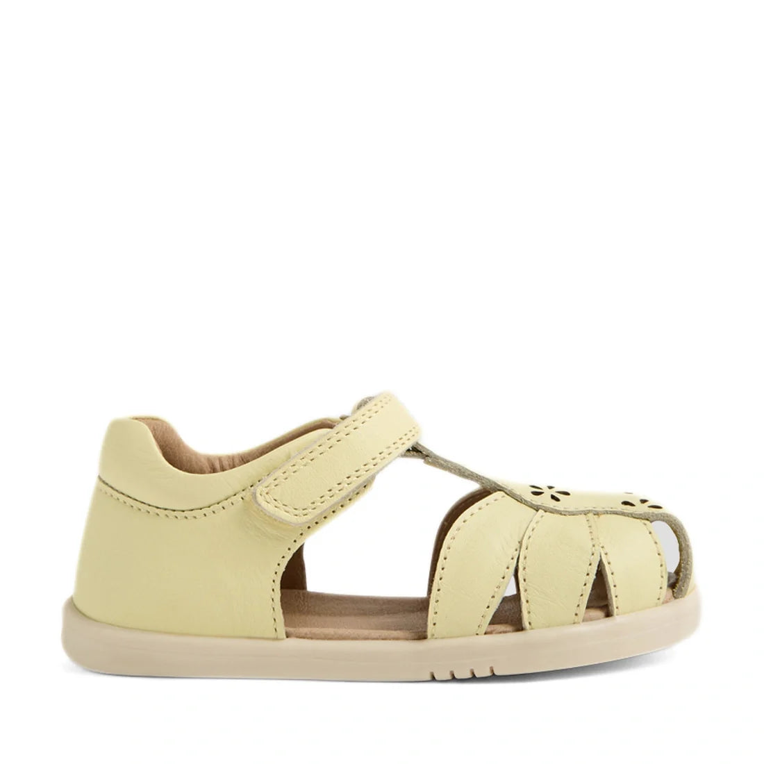 The Bobux IWalk Holly Toddlers Sandal in Wax Yellow is a closed-toe sandal for little explorers, crafted from quick-drying leather with a pale yellow finish. It features a closed heel, open sides, Velcro strap, and stylish cut-out details on the toe area—