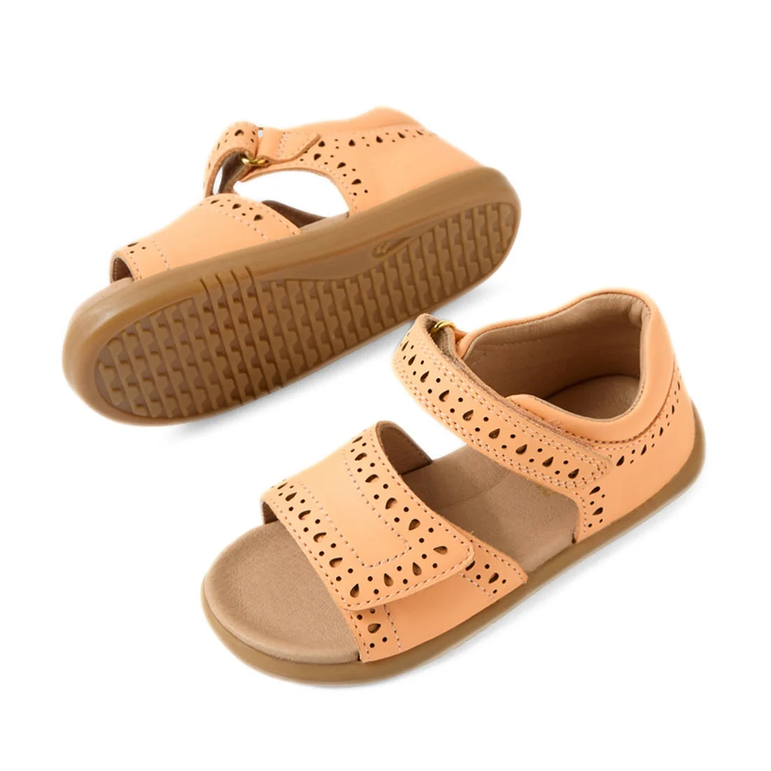 A pair of Bobux IWalk Logan Toddlers Sandal Peach Jelly Open Toe for girls, featuring a peach color, cutout details, Velcro straps, and durable rubber soles. These leather sandals are both stylish and practical—one sandal is displayed upright while the ot