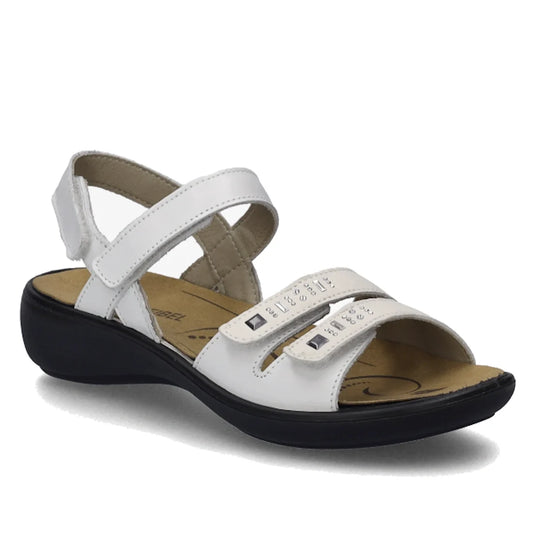 The Josef Seibel Ibiza 86 Womens Leather Comfort Sandal in White Weiss features two adjustable Velcro straps embellished with small silver studs, a supportive back strap, a cushioned tan insole, and a low black sole—offering the perfect combination of sty