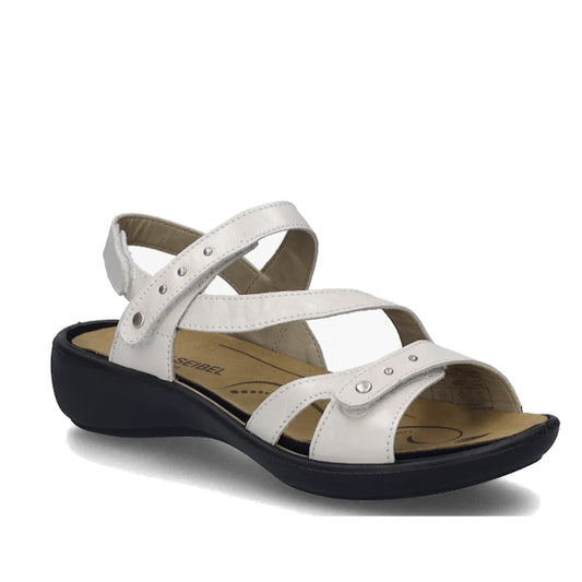 Step into iconic style with the Josef Seibel Ibiza 70 Women’s Leather Comfort Sandal in White, featuring white strappy leather uppers, an open toe, cushioned beige insole, a low black sole, ankle strap, and metallic stud detailing—perfect for channeling t