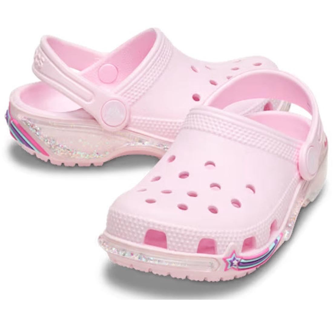 A pair of Pink children's Crocs clogs with star sparkle shaker design on a white background