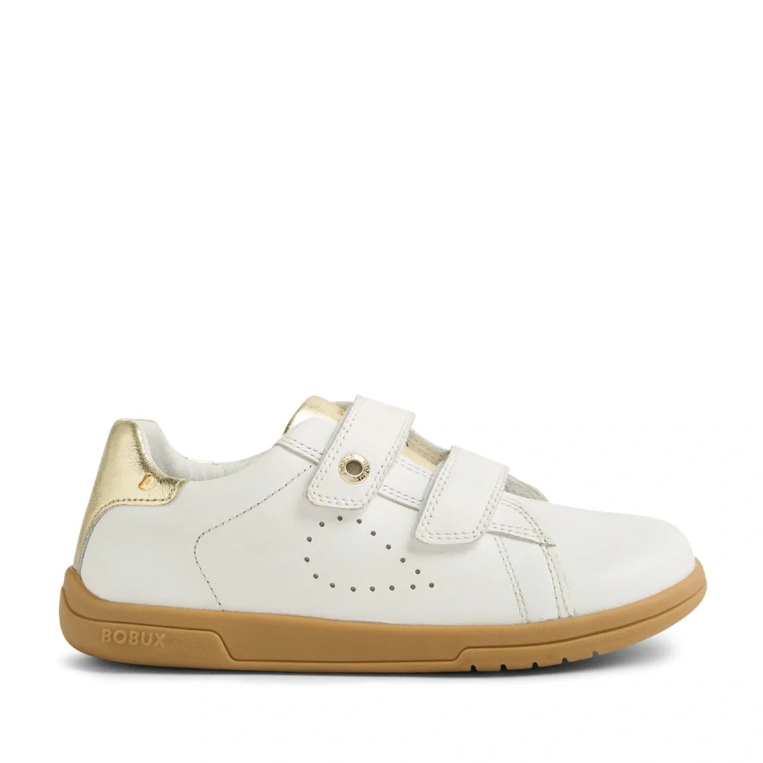 The Bobux Kid+ Plus KP Maverick Leather Sneaker White Gold features a white leather upper with perforated side detailing, a tan sole, gold heel accent, and two adjustable hook-and-loop straps for a secure fit. The BOBUX logo is displayed on the outer side