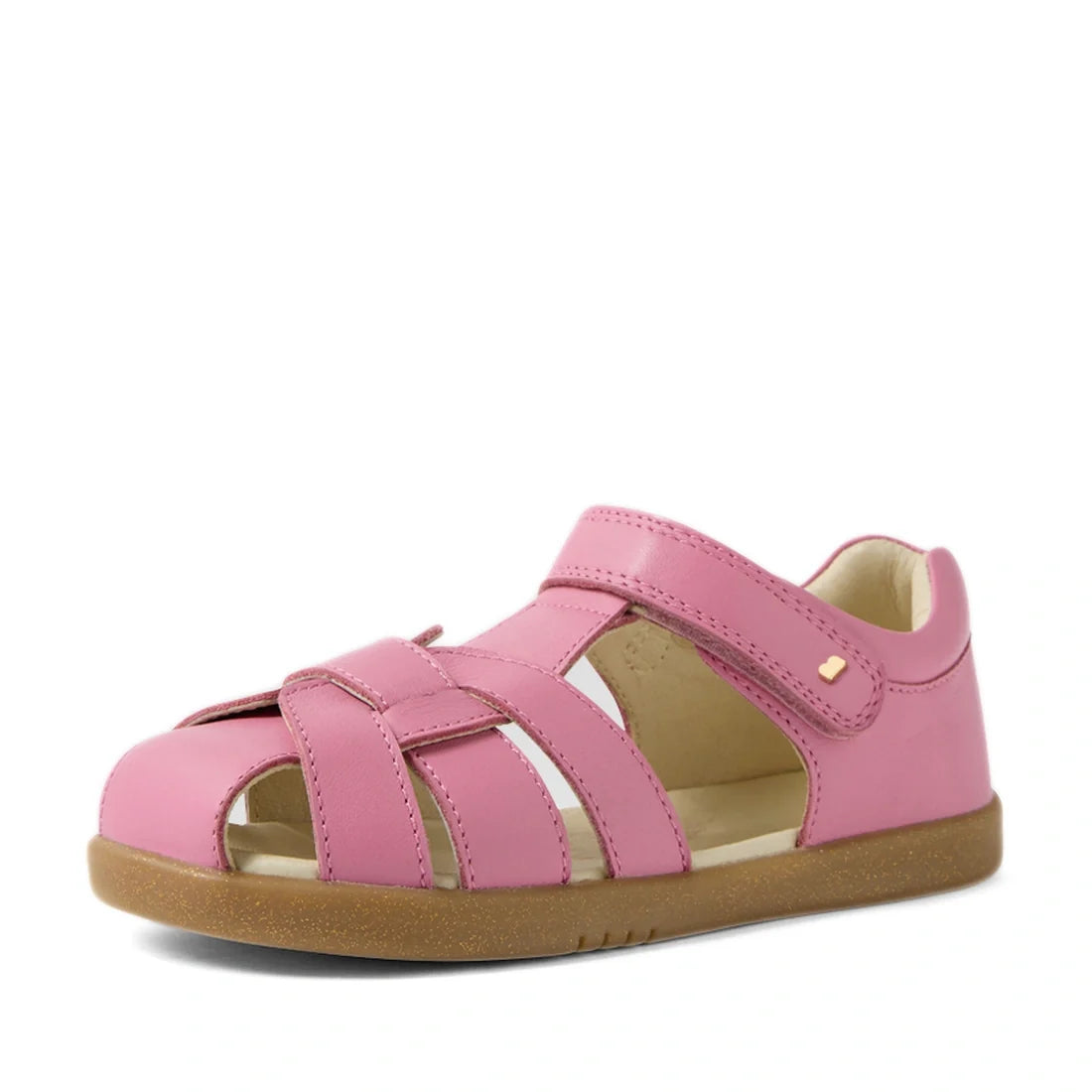 The Bobux Kids Plus KP Skip Twist Cashmere Rose Pink Closed Toe Sandal is a stylish children’s sandal featuring a smooth leather upper in rose pink, open sides, and a convenient Velcro strap. Designed with a light brown sole, this summer-ready sandal is p