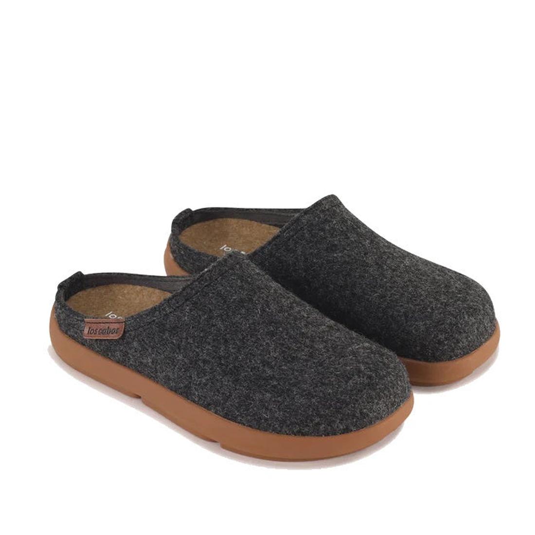 The Los Cabos Felton Graphic Black Women's Felted Slipper House Shoe features dark gray felt slip-on clogs with cushioned soles and brown rubber bottoms, perfect for indoor or casual wear, shown on a white background.