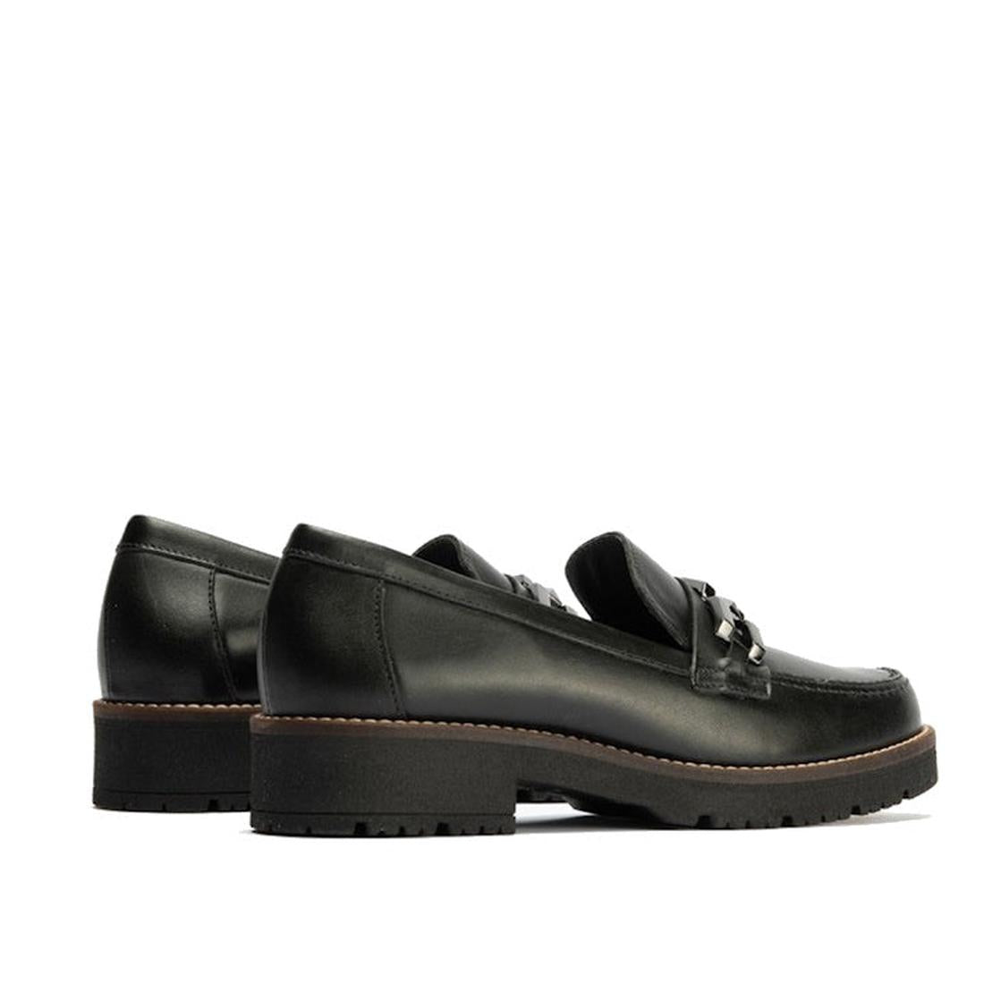 The Pitillos Womens Chunky Slip On Loafer 10775 features black nappa leather, chunky rubber soles, pewter front embellishment, and brown edge stitching. Made in Spain, the loafers are shown side by side facing left., 51931, 8445191665485, 8445191665492, 8