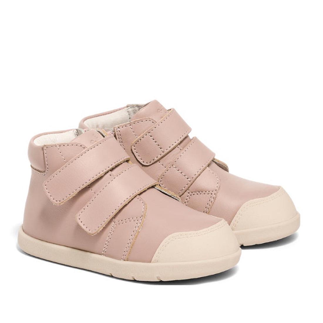 The Pretty Braver Blake Leather Boot First Walker Blush features light pink hi-top trainers with beige rubber soles and two Velcro straps, perfect for first walkers, shown on a plain white background.