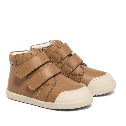 The Pretty Braver Blake Leather Boot First Walker Tan features a soft leather design in tan brown with white soles, two velcro straps for easy fastening, and a rounded shape ideal for toddlers and young kids.