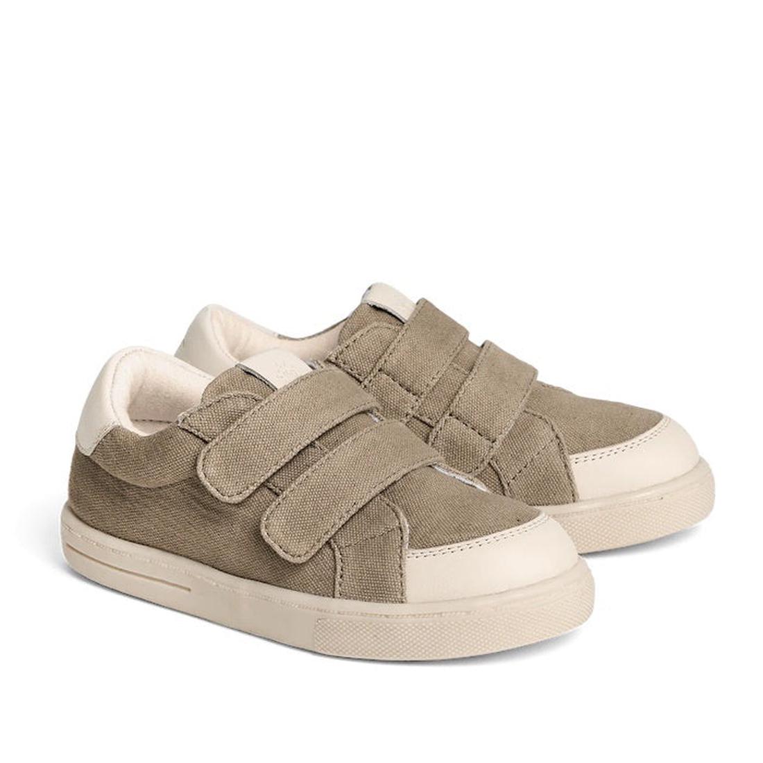 The Pretty Brave Otto Organic Canvas Trainer in khaki features beige soles, a leather toe buffer, and two Velcro straps per shoe, displayed against a white background.