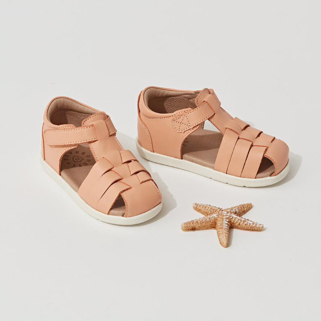 The Pretty Braver Billie First Walker Sandal Closed Back in Coral is displayed on a white background next to a small beige starfish, offering a lightweight, flexible sandal option ideal for early walkers., 9421036357141, 9421036357158, 9421036357165