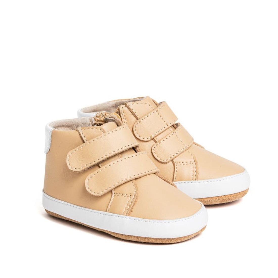 Pretty Brave Hi Top Camel Boot First Walker Baby features beige and white leather with two velcro straps on each shoe, soft soles, visible stitching, and a flexible outsole for extra comfort. Shown against a white background. CLEARANCE – NOT RETURNABLE.