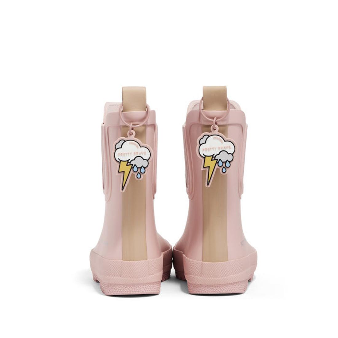 A pair of Pretty Brave Puddle Boot Ankle Rainboot NEW in Muted Blush Pink, shown from the back, each with a patch featuring a cartoon cloud, raindrops, lightning bolt, and "PRETTY SMART". Lightweight and waterproof for kids., 9420075349926, 9420075349919,