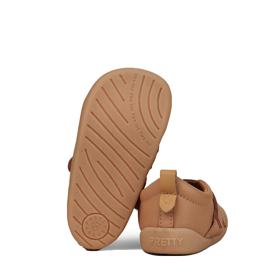 The Pretty Brave First Walker Toto Leather Trainer in Tan features soft soles; one shoe stands upright revealing its textured sole, while the other lies on its side displaying "PRETTY" embossed on the heel., 9420075366183, 9420075366176, 9420075366169, 94