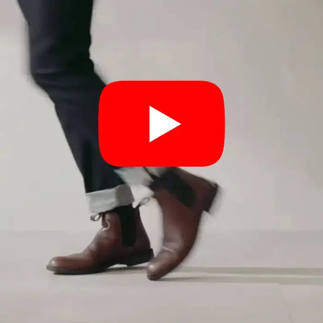 A person in dark pants wears Blundstone 063 Black Dress Chelsea Boots featuring elastic side panels and sturdy soles, walking by a YouTube logo.  ksnz