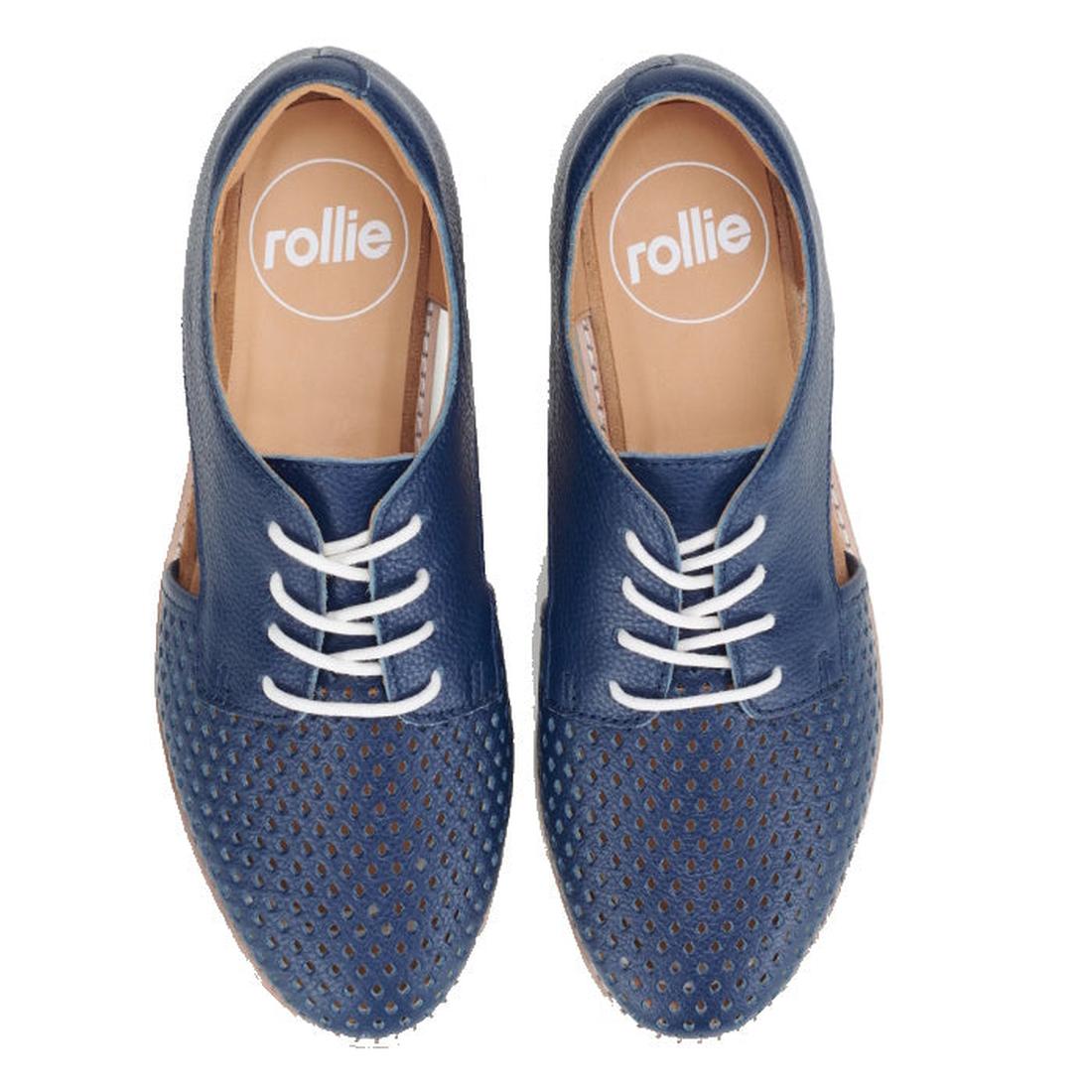The Rollie Womens Sidecut Punch Navy Tumble Leather Shoe is a blue lace-up with white laces, tan insoles, punch hole toe detailing, "rollie" branding inside, and breathable linings. Shoes are viewed from above., 9781760775414, 9781760775421, 9781760775438